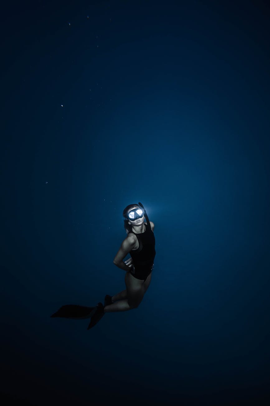 unrecognizable woman diving in blue sea water